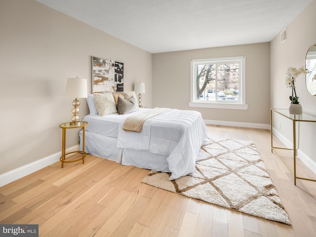 bedroom with wood-type flooring and a textured ceiling