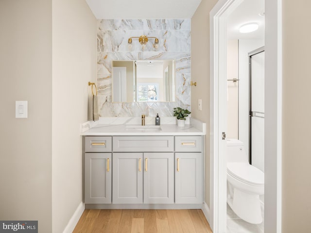 bathroom with wood-type flooring, toilet, and vanity