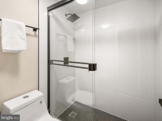 bathroom with toilet and a shower with shower door