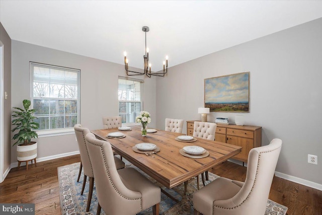 dining area with an inviting chandelier and dark wood-type flooring