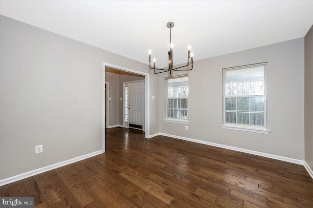 unfurnished dining area featuring dark hardwood / wood-style flooring and a notable chandelier