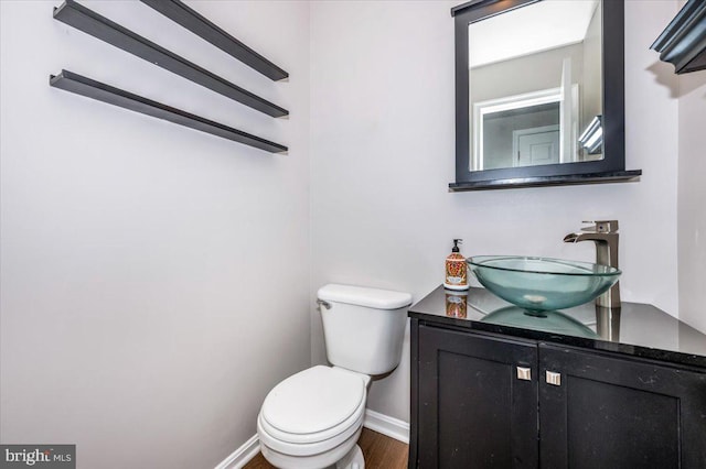 bathroom with vanity, toilet, and hardwood / wood-style floors