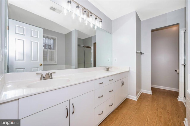 bathroom featuring vanity, hardwood / wood-style floors, and walk in shower