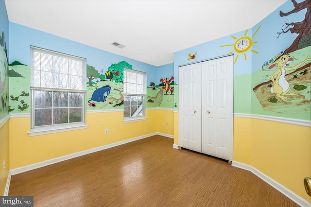 unfurnished bedroom with hardwood / wood-style flooring and a closet