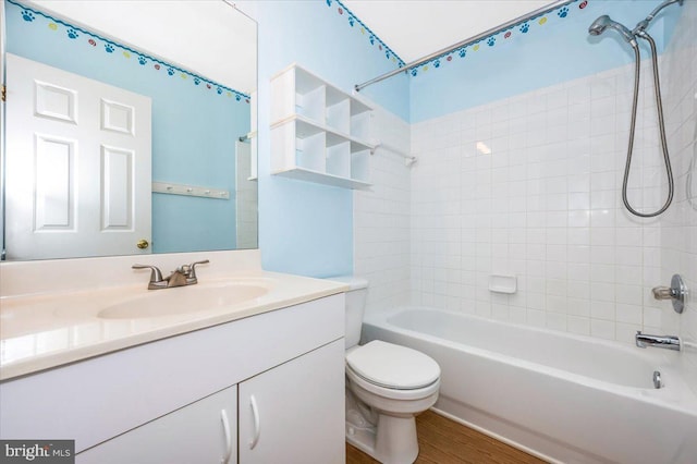 full bathroom featuring tiled shower / bath, vanity, toilet, and wood-type flooring