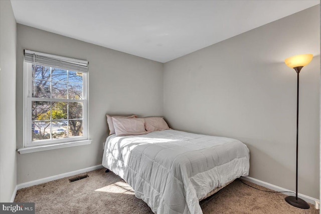 carpeted bedroom featuring baseboards and visible vents