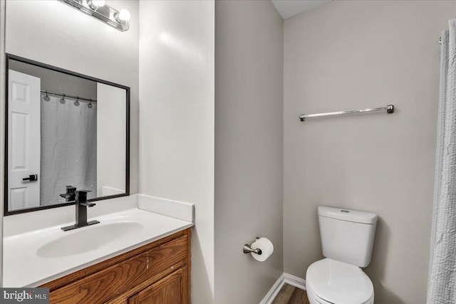 full bath with vanity, toilet, and baseboards