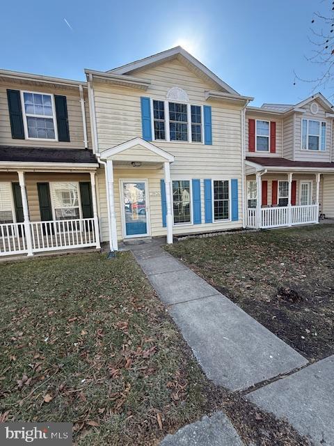 view of property with a porch and a front yard