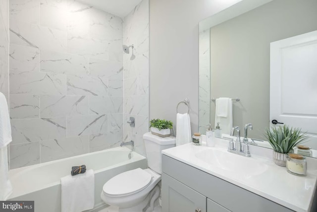 full bathroom with tiled shower / bath, vanity, and toilet