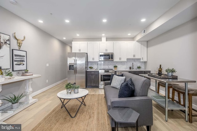 living room with sink and light wood-type flooring