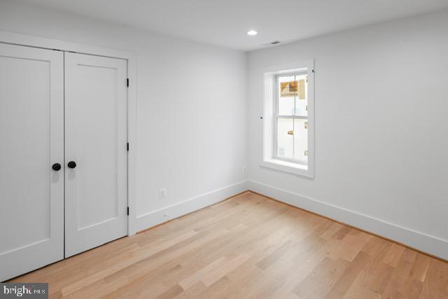 unfurnished bedroom with light hardwood / wood-style floors and a closet