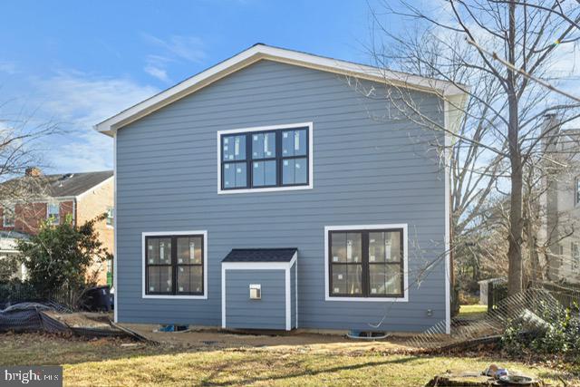 rear view of property featuring a yard