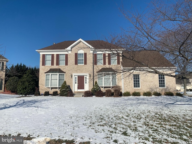 colonial inspired home with brick siding