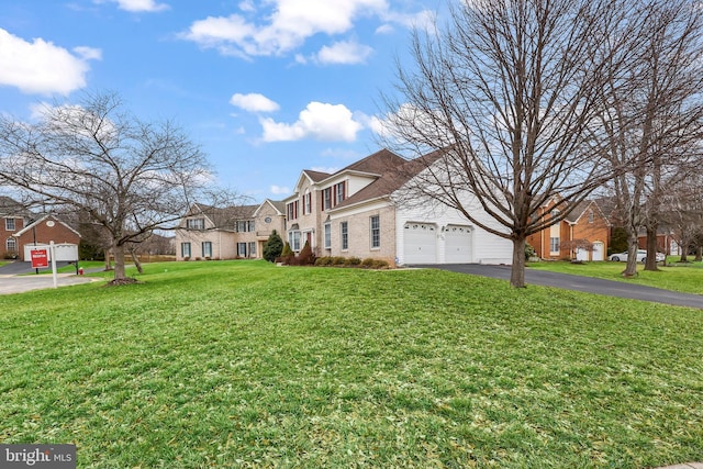 exterior space with aphalt driveway, a residential view, brick siding, and a yard