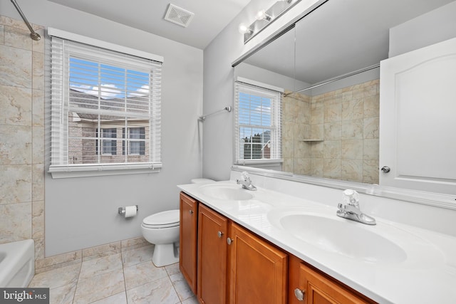 full bathroom with vanity, tiled shower / bath combo, and toilet