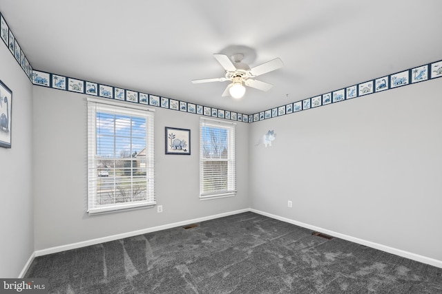 empty room with ceiling fan and dark carpet