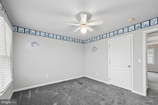 unfurnished bedroom featuring ceiling fan and dark colored carpet