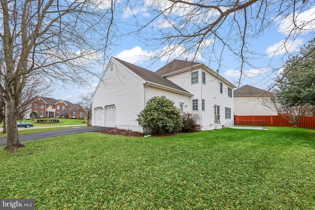 view of side of home with a yard and a garage