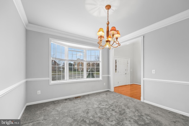 carpeted empty room with crown molding and a chandelier