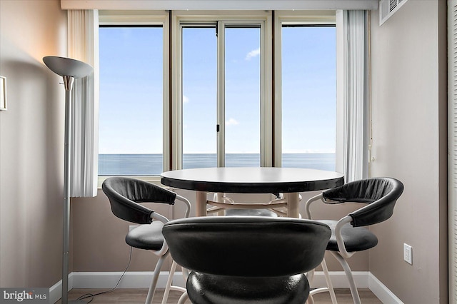 dining space with a water view and wood-type flooring