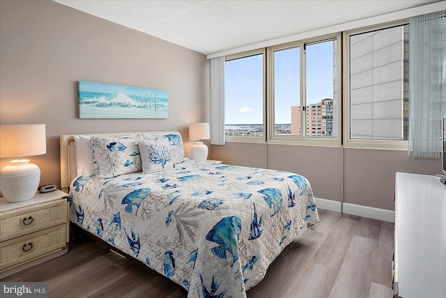 bedroom with a textured ceiling and light hardwood / wood-style flooring