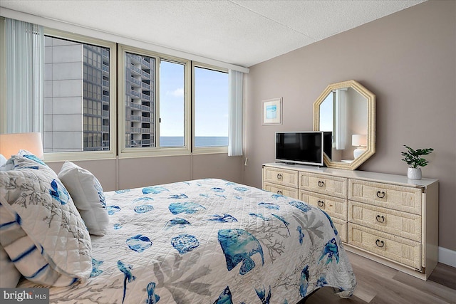 bedroom with a textured ceiling and light hardwood / wood-style floors