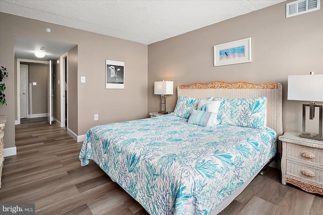 bedroom featuring dark wood-type flooring and a textured ceiling