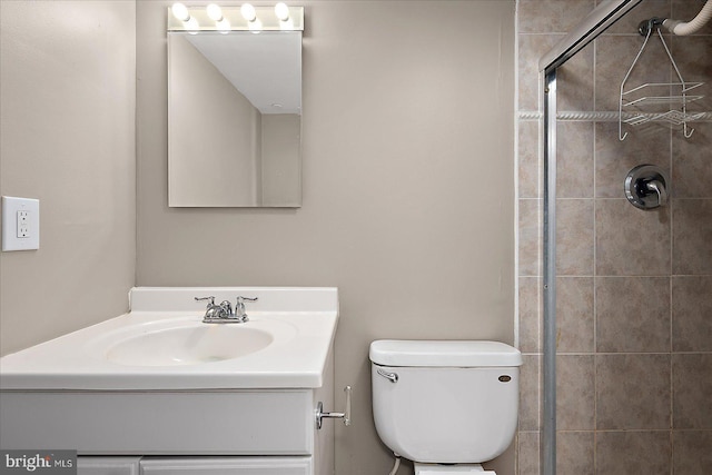 bathroom with toilet, vanity, and an enclosed shower