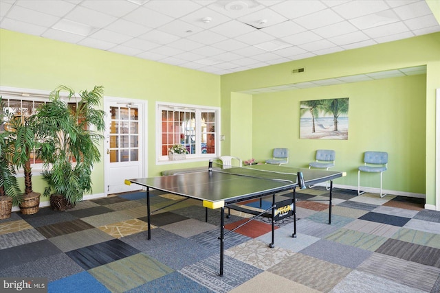 playroom with carpet floors and a drop ceiling