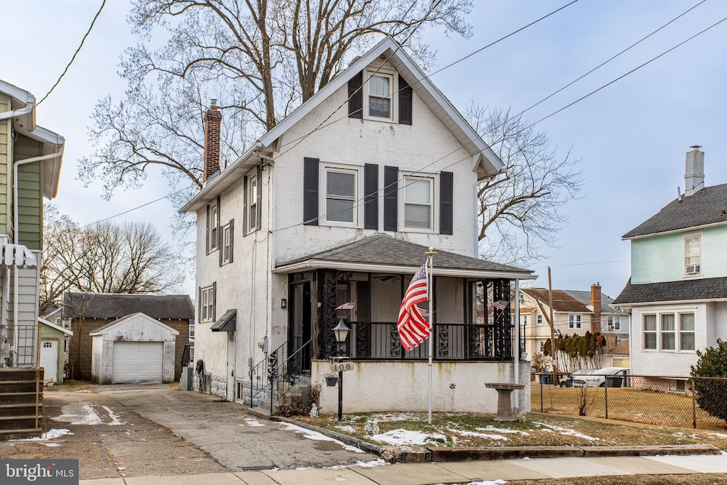 view of front of property featuring a garage, an outdoor structure, and a porch