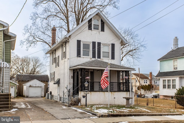 view of front of property featuring a garage, an outdoor structure, and a porch