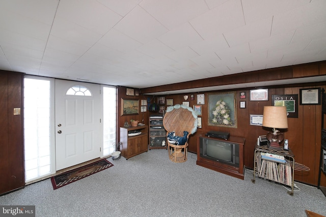 carpeted entryway with wooden walls