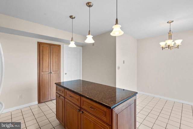 kitchen featuring pendant lighting, a notable chandelier, dark stone countertops, and light tile patterned flooring