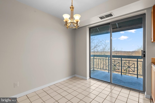 empty room with a chandelier and light tile patterned flooring