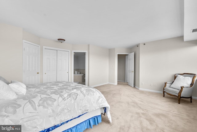 bedroom with light colored carpet and connected bathroom