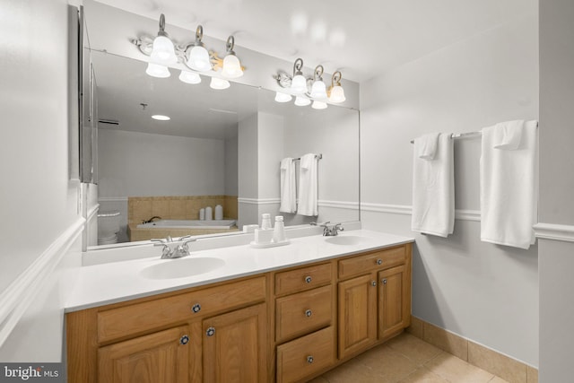 bathroom featuring tile patterned flooring, a bath, and vanity