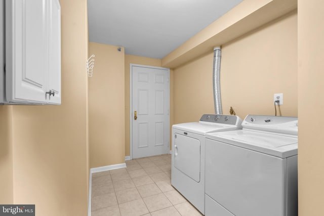 laundry area with cabinets, washer and clothes dryer, and light tile patterned floors