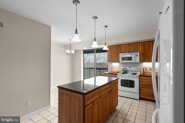 kitchen with a center island, pendant lighting, white appliances, and light tile patterned floors