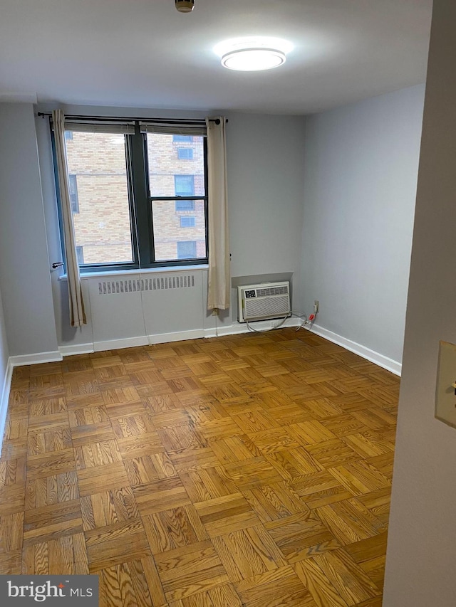 spare room with parquet flooring and an AC wall unit