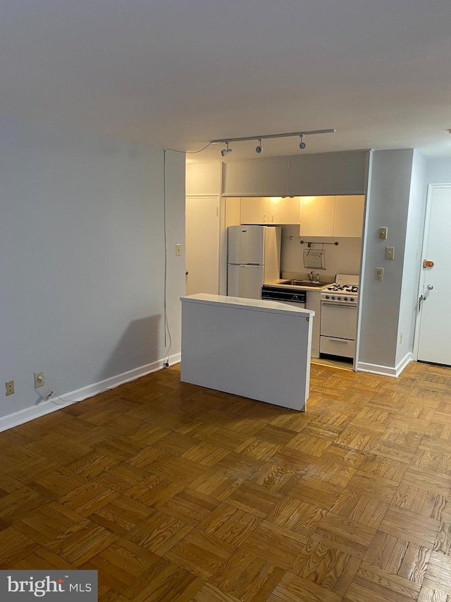 kitchen featuring light parquet flooring, sink, white cabinets, and white appliances