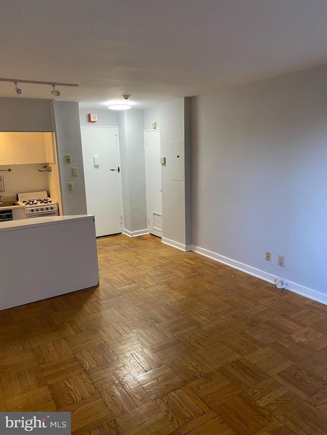 unfurnished room featuring parquet floors and track lighting