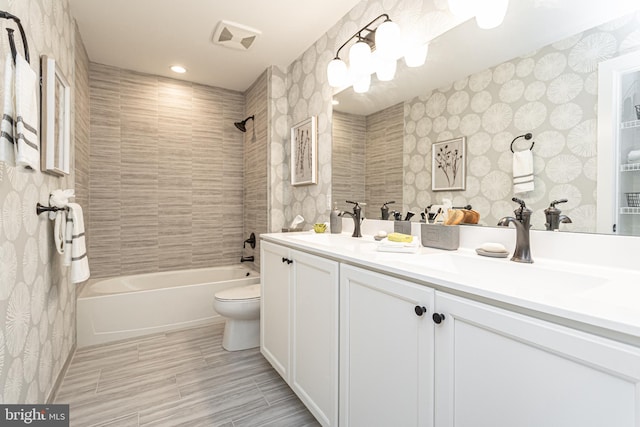 full bathroom featuring toilet, vanity, and tiled shower / bath