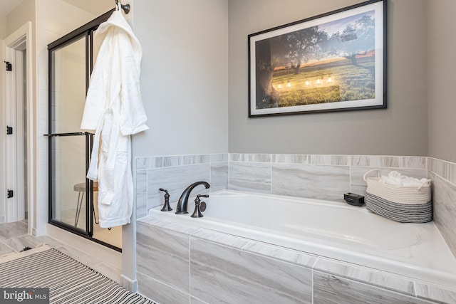 bathroom featuring independent shower and bath