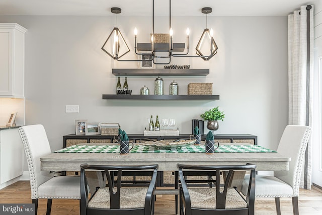 bar featuring decorative light fixtures, light hardwood / wood-style floors, and white cabinetry