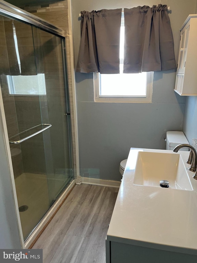 bathroom with vanity, hardwood / wood-style flooring, toilet, and walk in shower