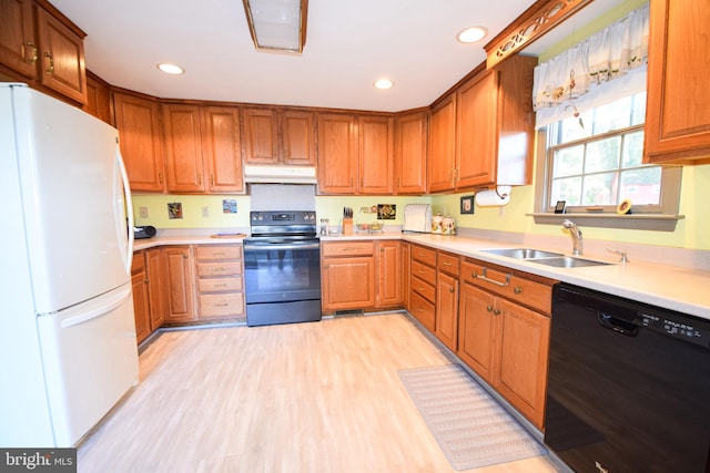 kitchen with sink, black appliances, and light wood-type flooring