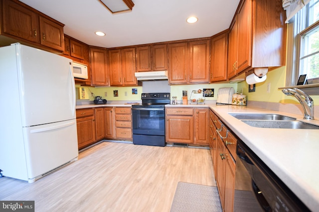 kitchen with black appliances, light hardwood / wood-style floors, and sink