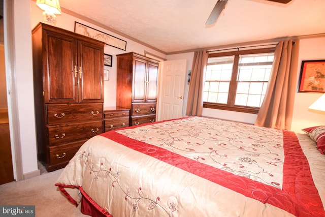 carpeted bedroom with crown molding and ceiling fan