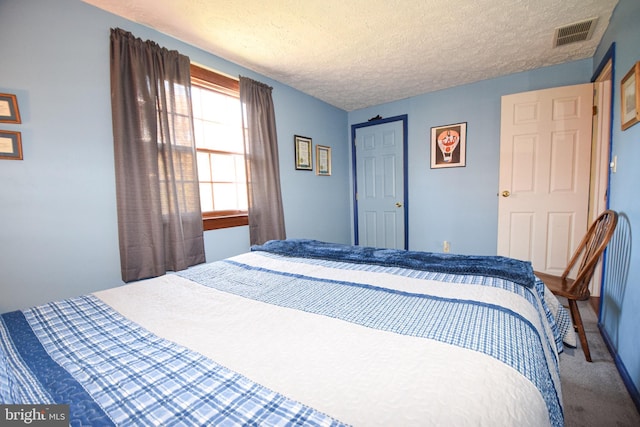 carpeted bedroom with a textured ceiling