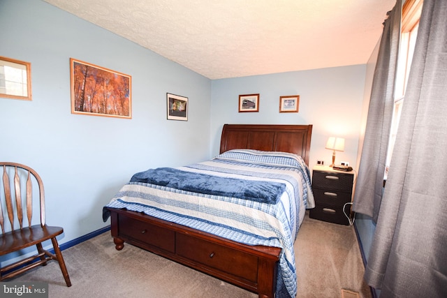 bedroom featuring light colored carpet and a textured ceiling